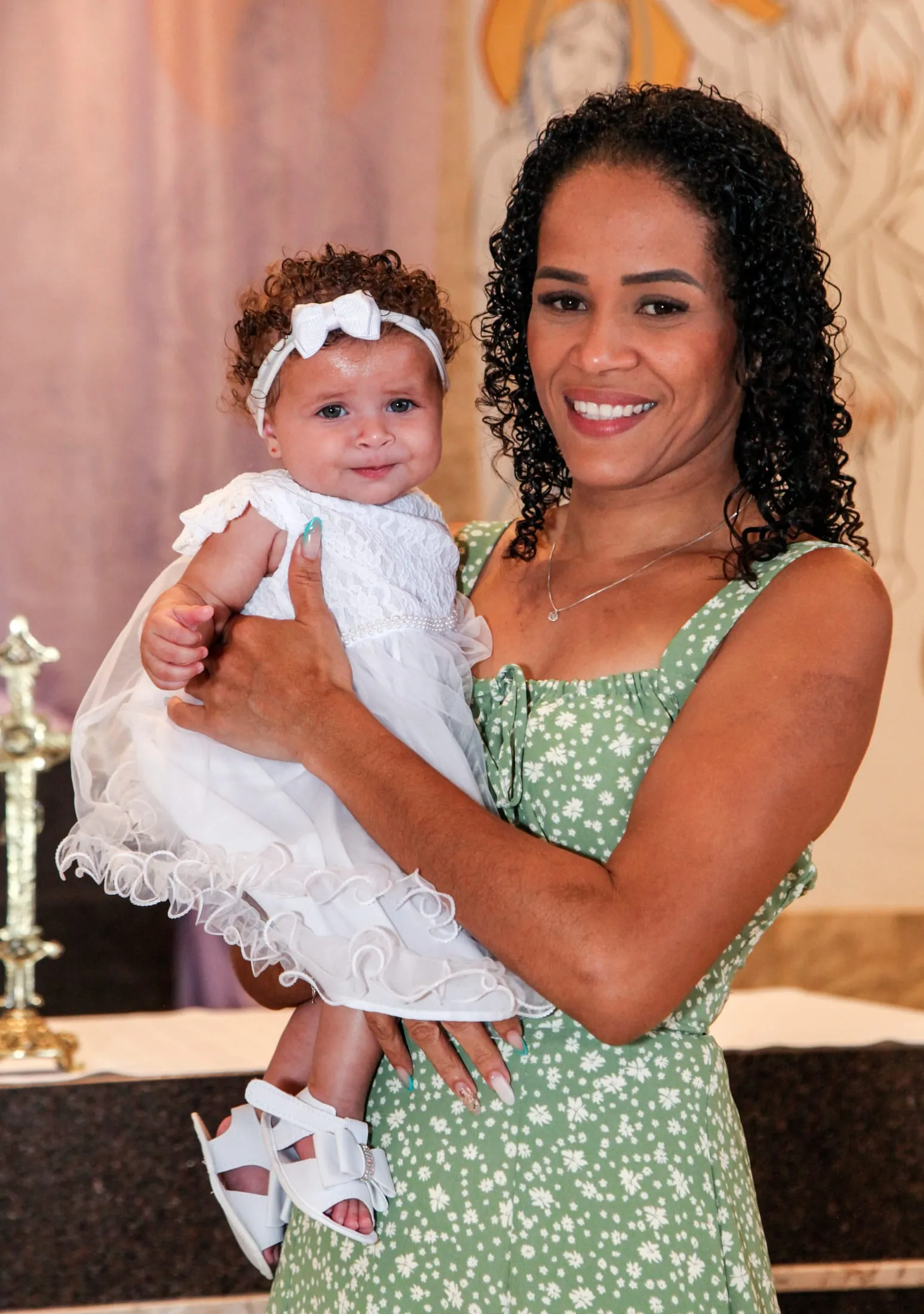 Batizado em Piracicaba — mãe com a menina vestida de branco no colo