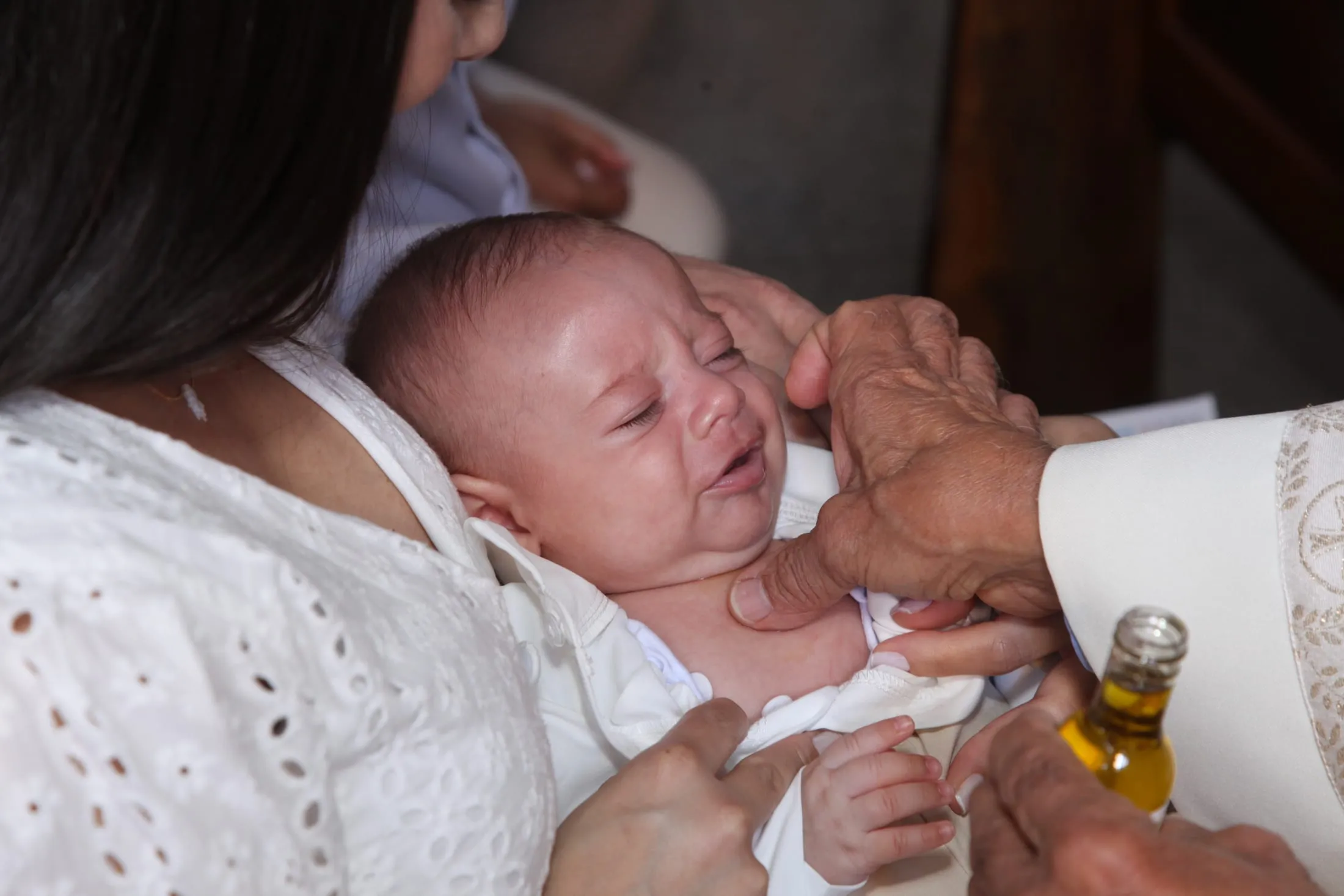 Batismo em Piracicaba — unção do bebê com o óleo santo