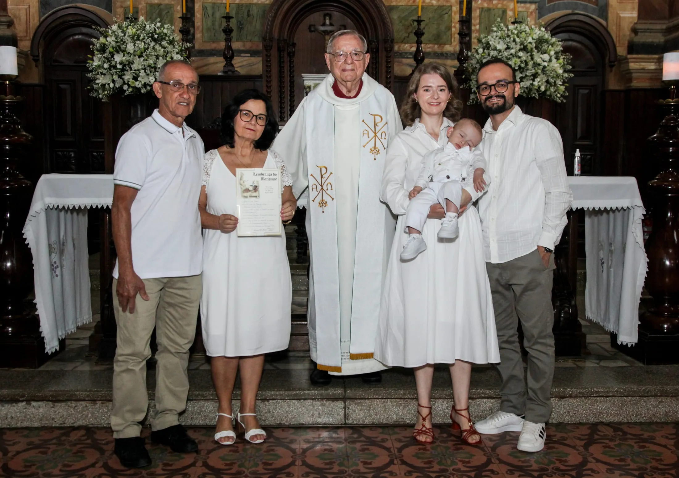 Fotografia de batismo em Piracicaba — família reunida com o padre