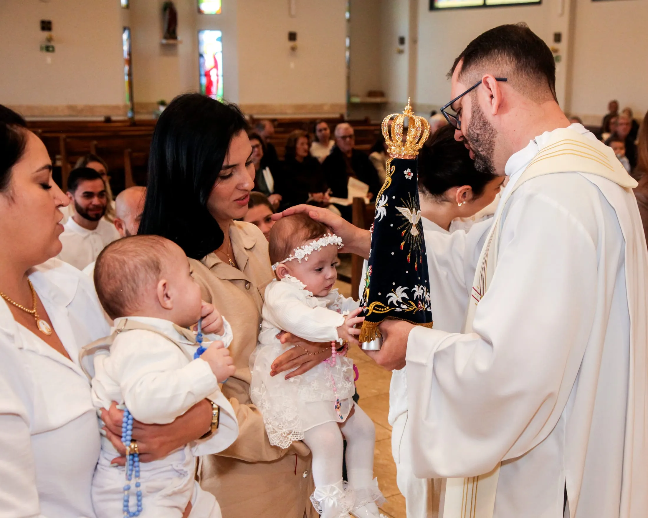 Fotógrafo de batizado em Piracicaba — padre apresentando a veste branca aos bebês