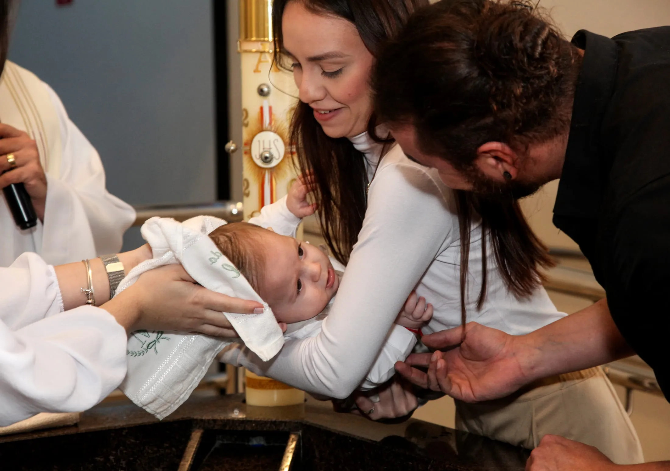 Batizado em Piracicaba — padre enxugando o bebê com a toalha na pia batismal
